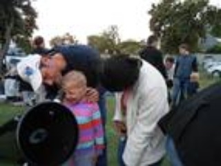 Parents assisting their children to view the evening sky